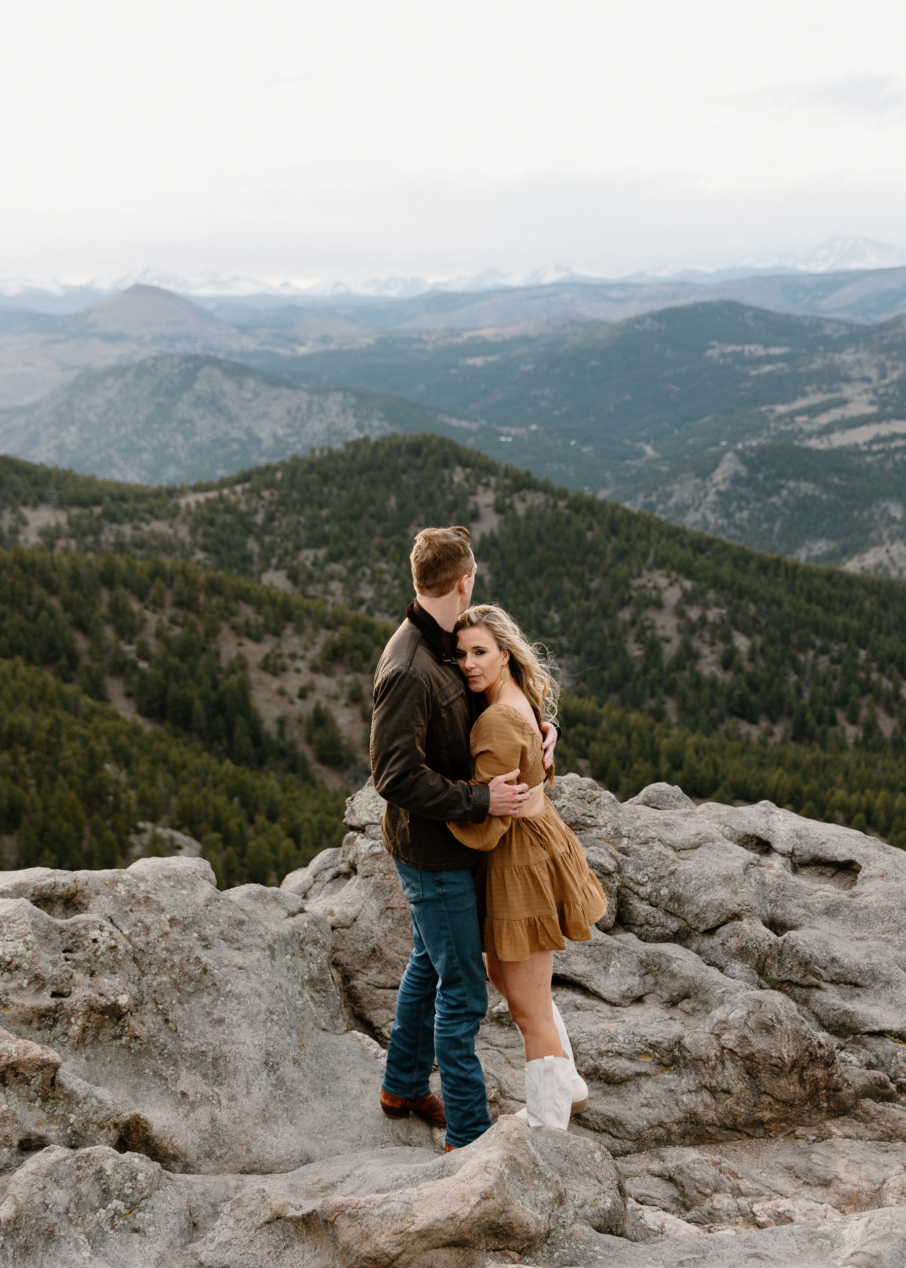 Adventurous couple embracing at Lost Gulch Overlook in Colorado, surrounded by stunning mountain vistas.