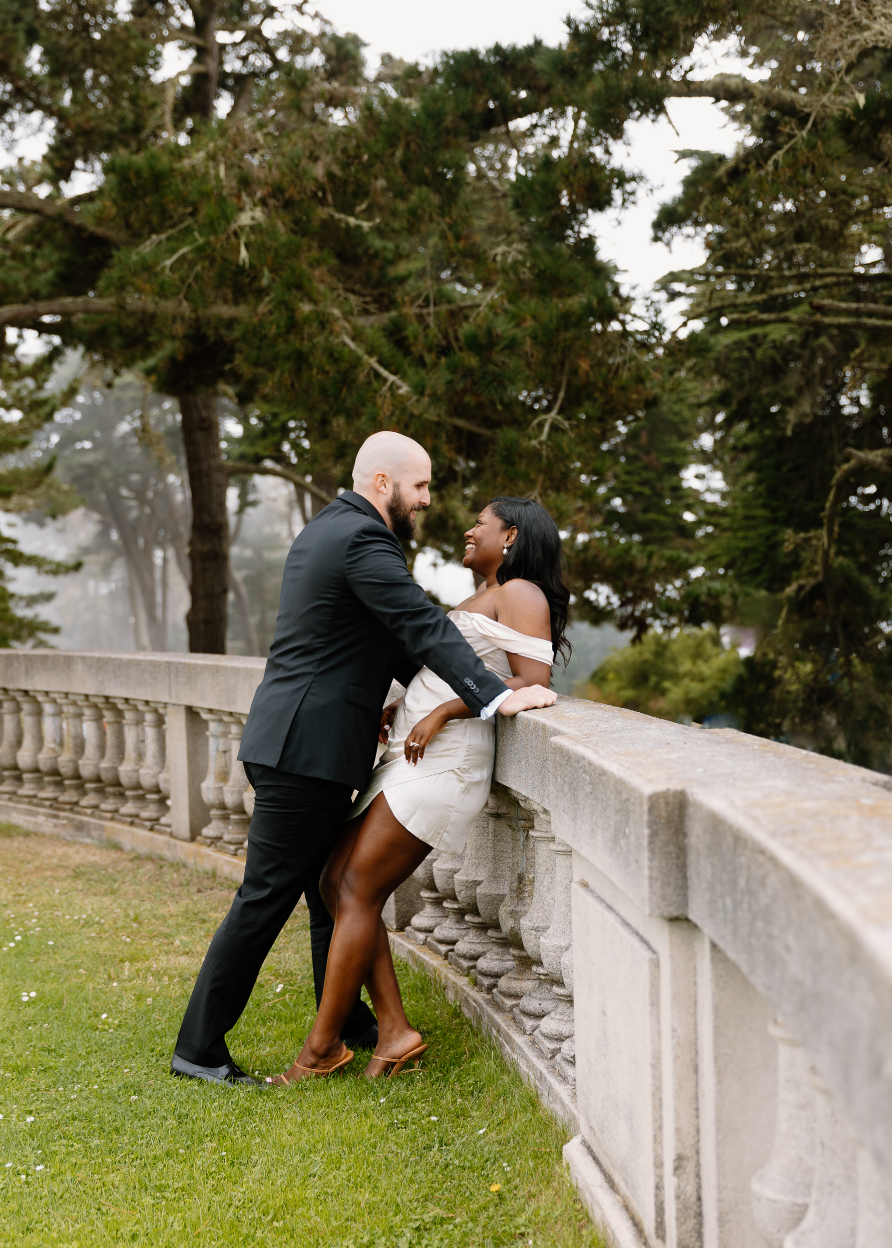 A shot of the couple framed against a fog-draped sculpture, capturing the blend of nature, art, and love at the Legion of Honor.